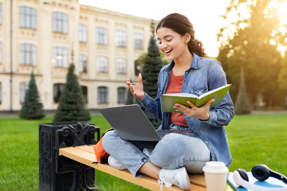 
Young indian woman student have online class sitting on bench